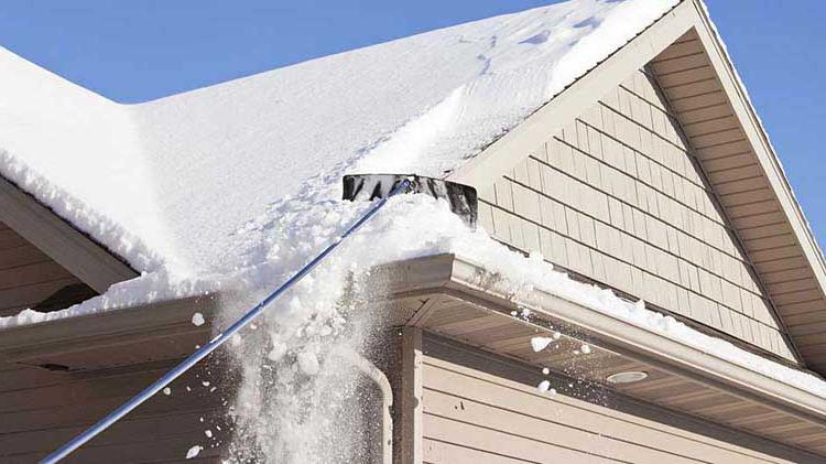 A roof snow removal tool is used to clear snow from a roof.
