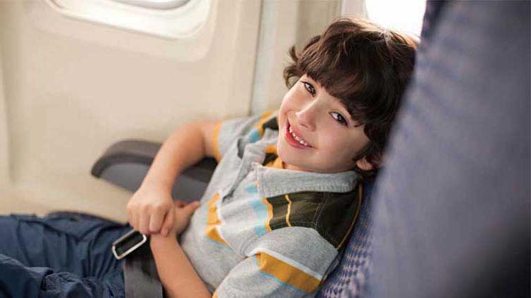 Young boy sitting in an airplane seat.