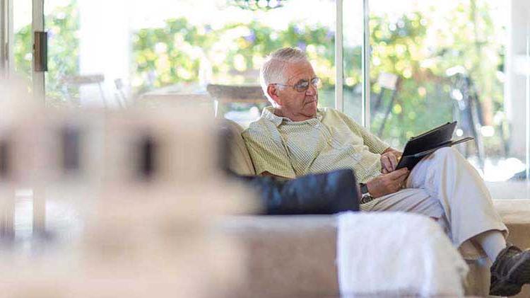 An elderly man on his couch researching 医疗pp王者电子官网 online.