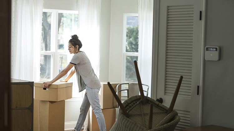 一名妇女在收拾行李准备离婚后搬家时倚在一个包装箱上