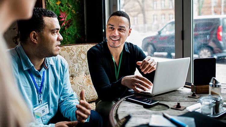 两个男人在谈论小企业的好处和在笔记本电脑上工作.