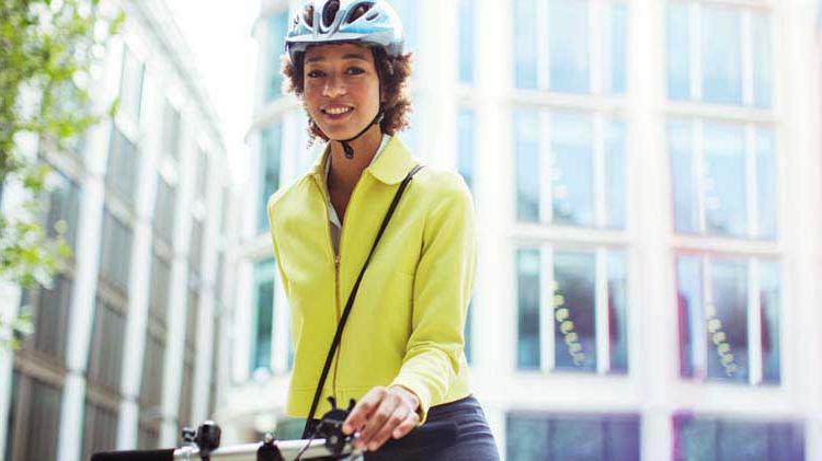 一个戴着头盔骑自行车去上班的女人